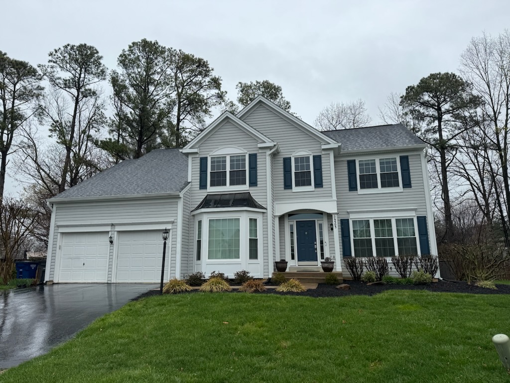 Cream-sided colonial home with a front-facing bay window and double garage.