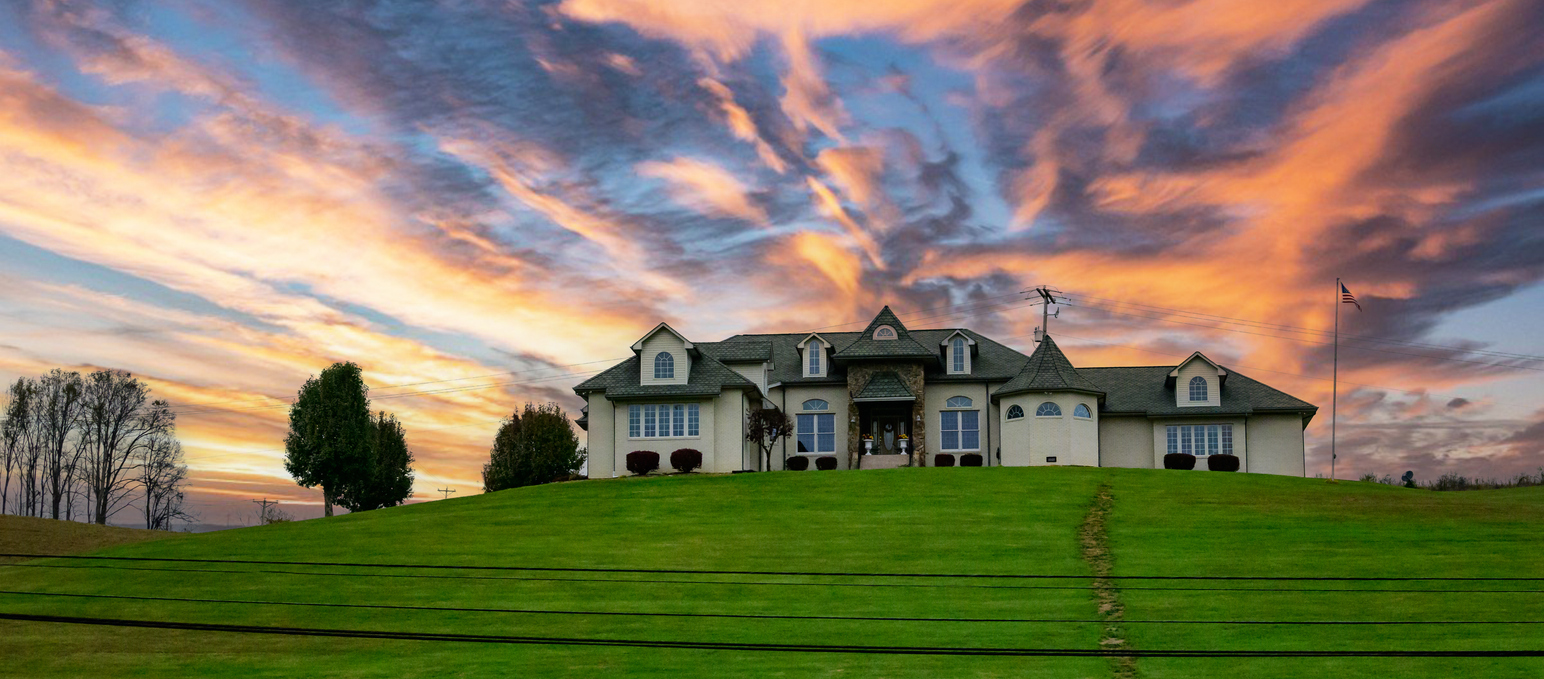 Large hilltop home on acreage at sunset