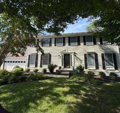 Colonial home with original tan siding before Virginia Exteriors Mastic siding and shutters